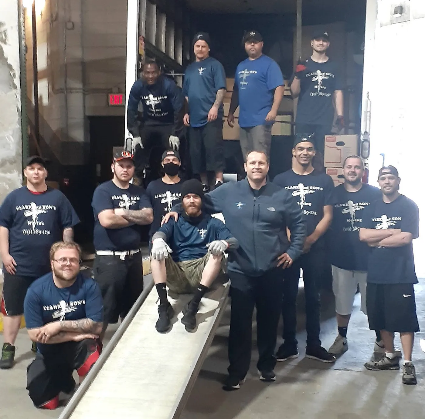 The Clark and Sons crew standing together on a truck ramp in company shirts