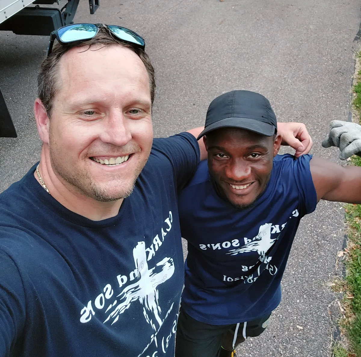 Two Clark and Sons movers smiling together in company shirts