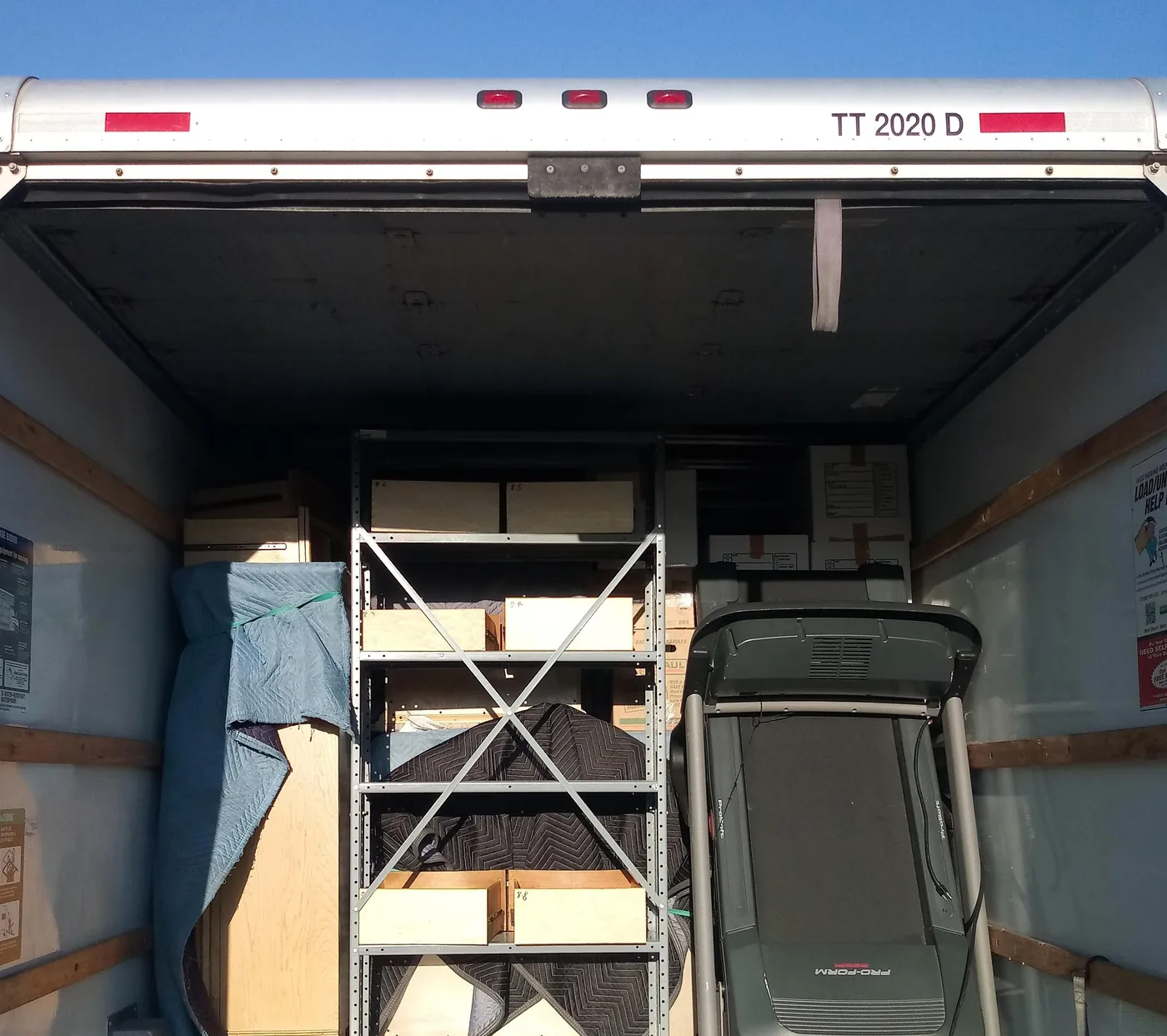 The inside of a Clark and Sons truck, loaded floor to ceiling with wrapped furniture and boxes